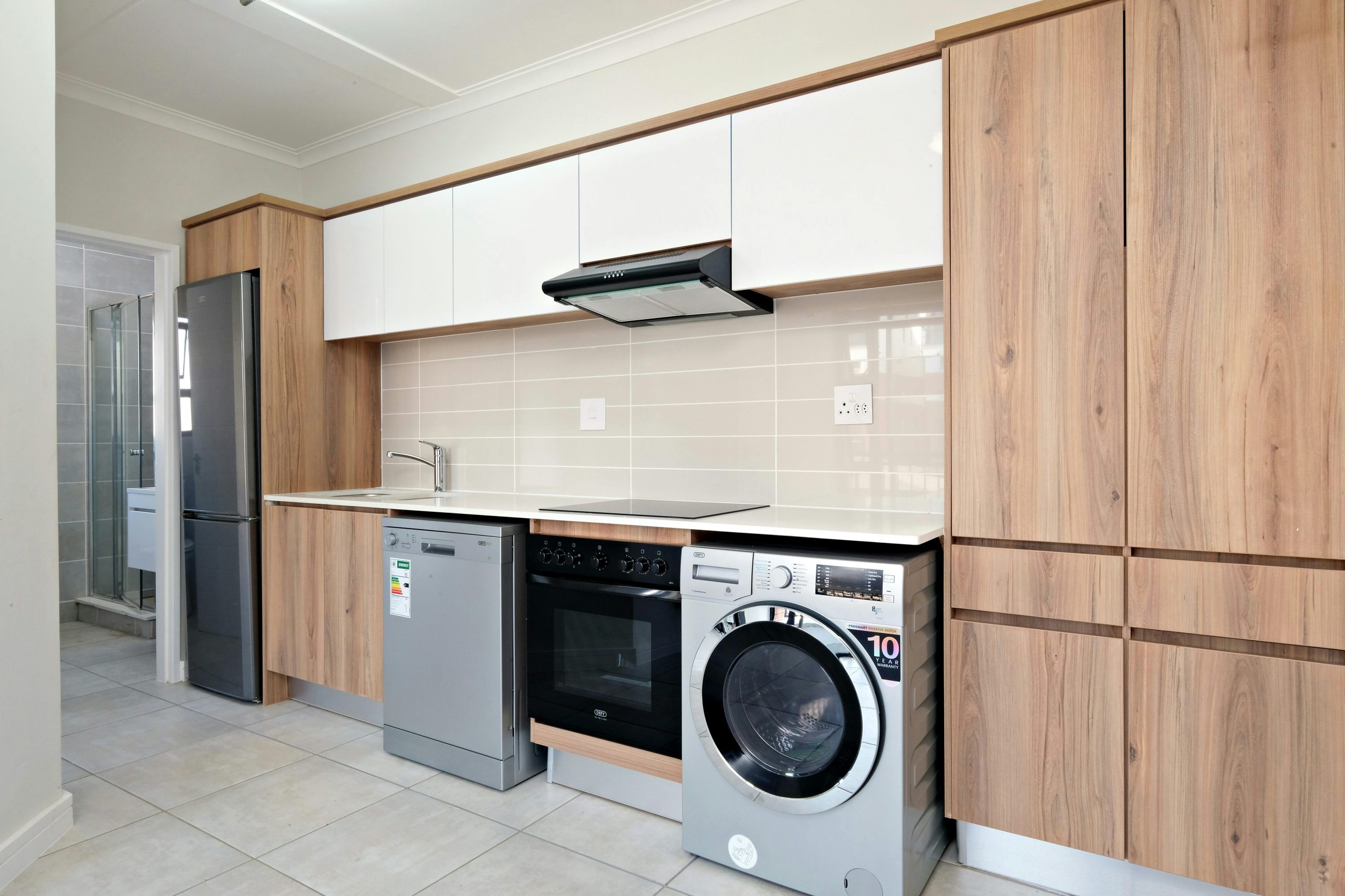 A sleek modern kitchen design featuring wooden cabinetry and integrated appliances.